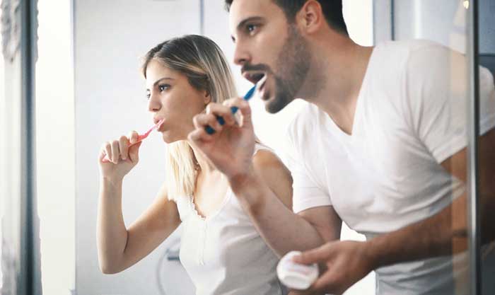 A boy and a girl brushing teeth together