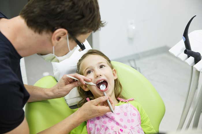 Dentist treating small girl