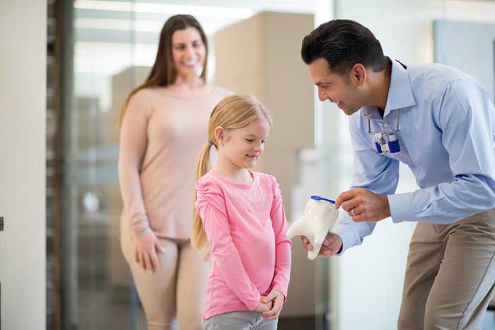 Daughter with her mother talking to the dentist