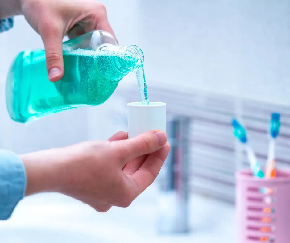 person using mouthwash